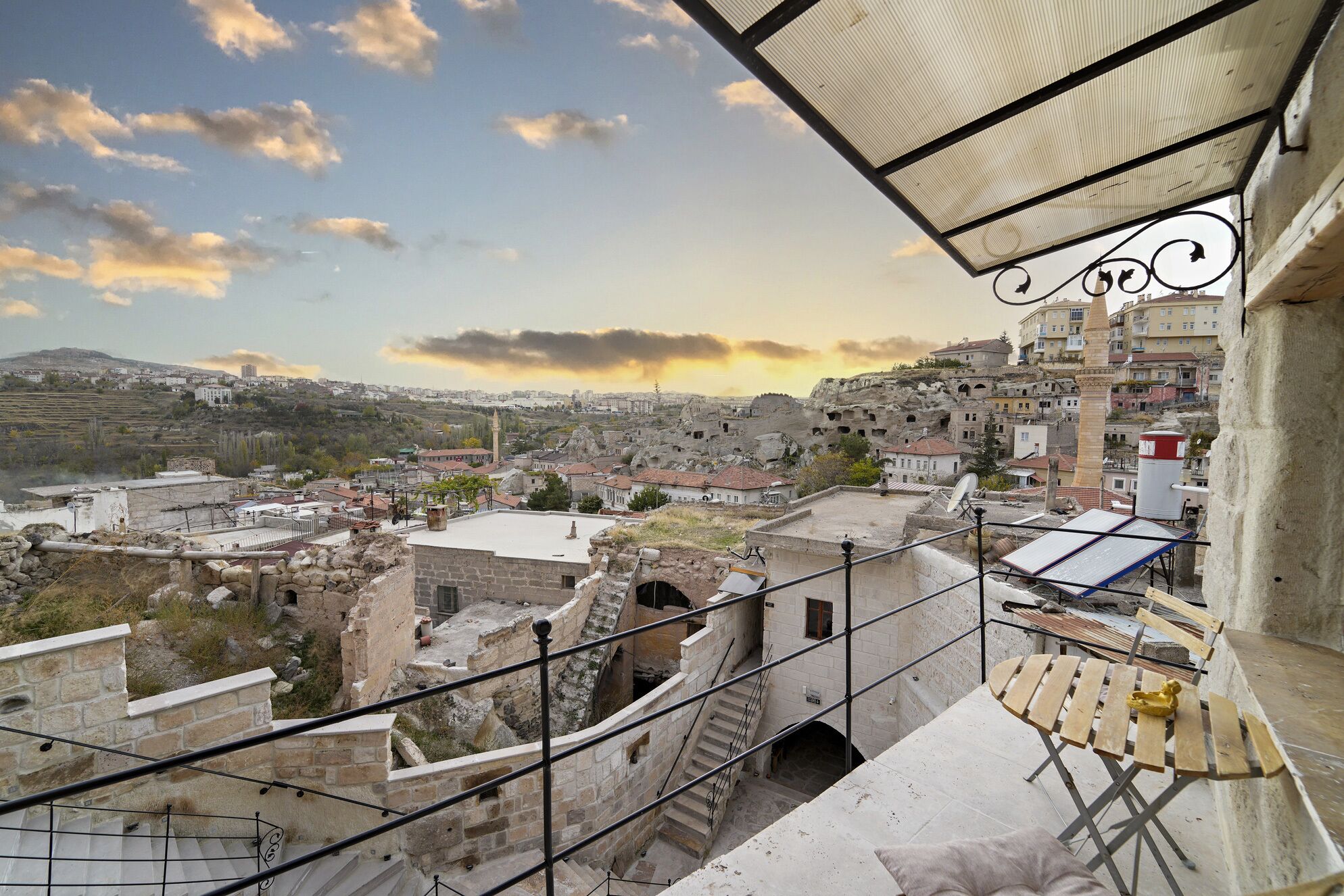 Un balcon offrant une vue sur le paysage urbain, avec notamment des bâtiments historiques et une mosquée.