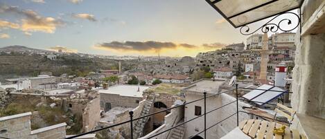 Un balcon offrant une vue sur le paysage urbain, avec notamment des bâtiments historiques et une mosquée.