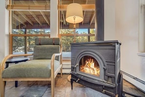 A cozy room with a fireplace, a comfortable chair, and a table.