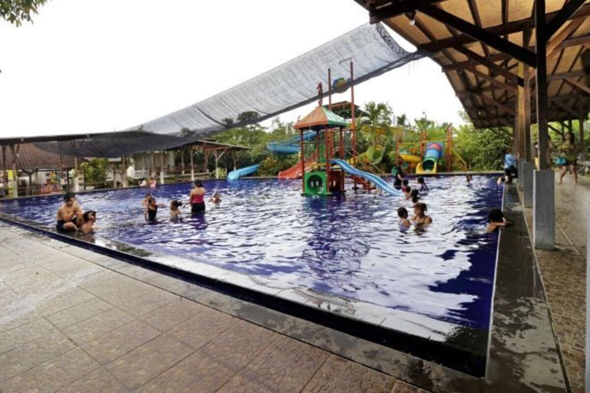 Una piscina interior con varias toboganes y una zona cubierta.