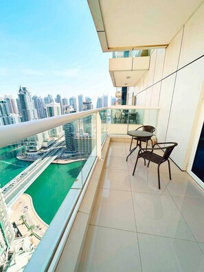 A balcony with a view of a city skyline and a body of water. - Lux High Rise Marina Apartment (Dubai)