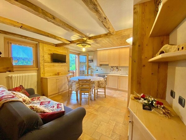 Un interior acogedor con comedor, cocina y sofá.
