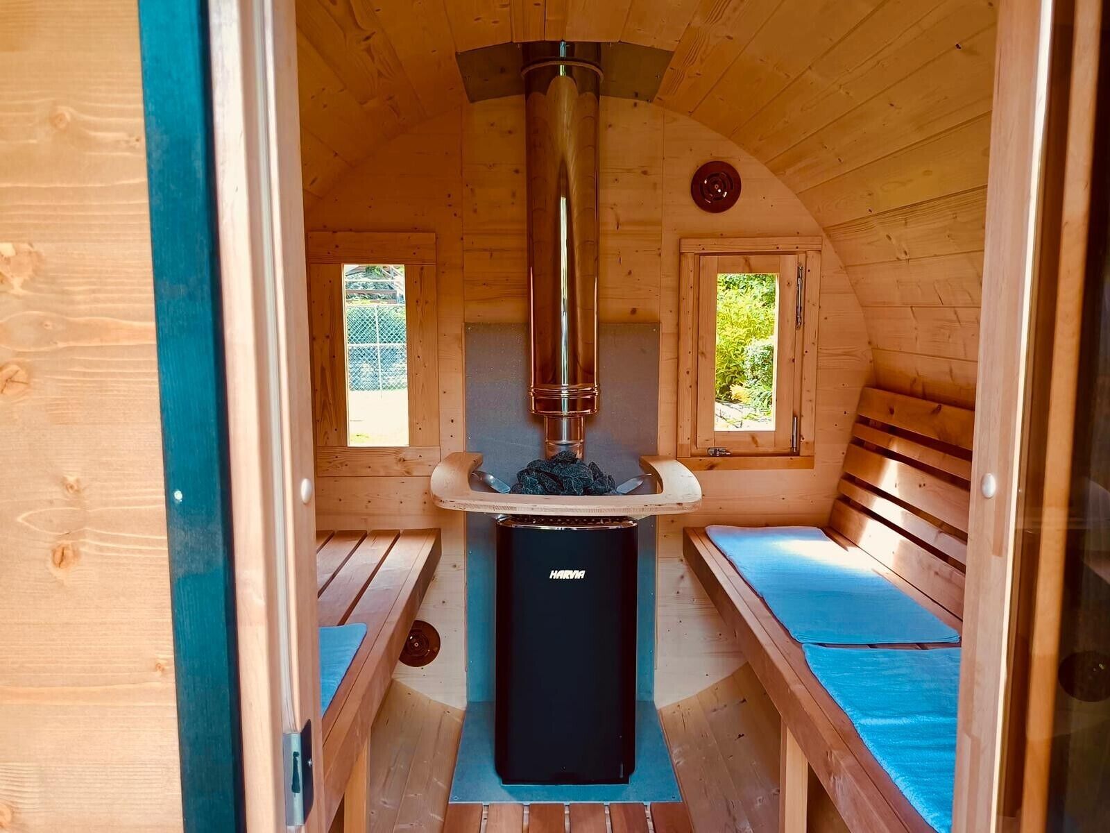 Una sala de sauna con calefacción central, bancos y ventanas.