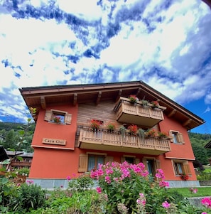 Un bâtiment à deux étages, sur lequel on peut lire l’inscription « Casa Club », et doté de balcons ornés de jardinières fleuries.