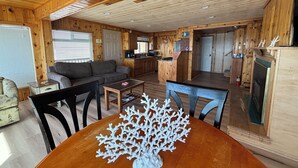 Interior acogedor de una cabaña con comedor, cocina y sala de estar.