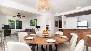 A modern dining area with a round glass table, white chairs, and a fruit bowl centerpiece. - Amazing ocean view from Estrellita de Mar 303 2BD Condo for rent in Amapas, Puer (Puerto Vallarta)