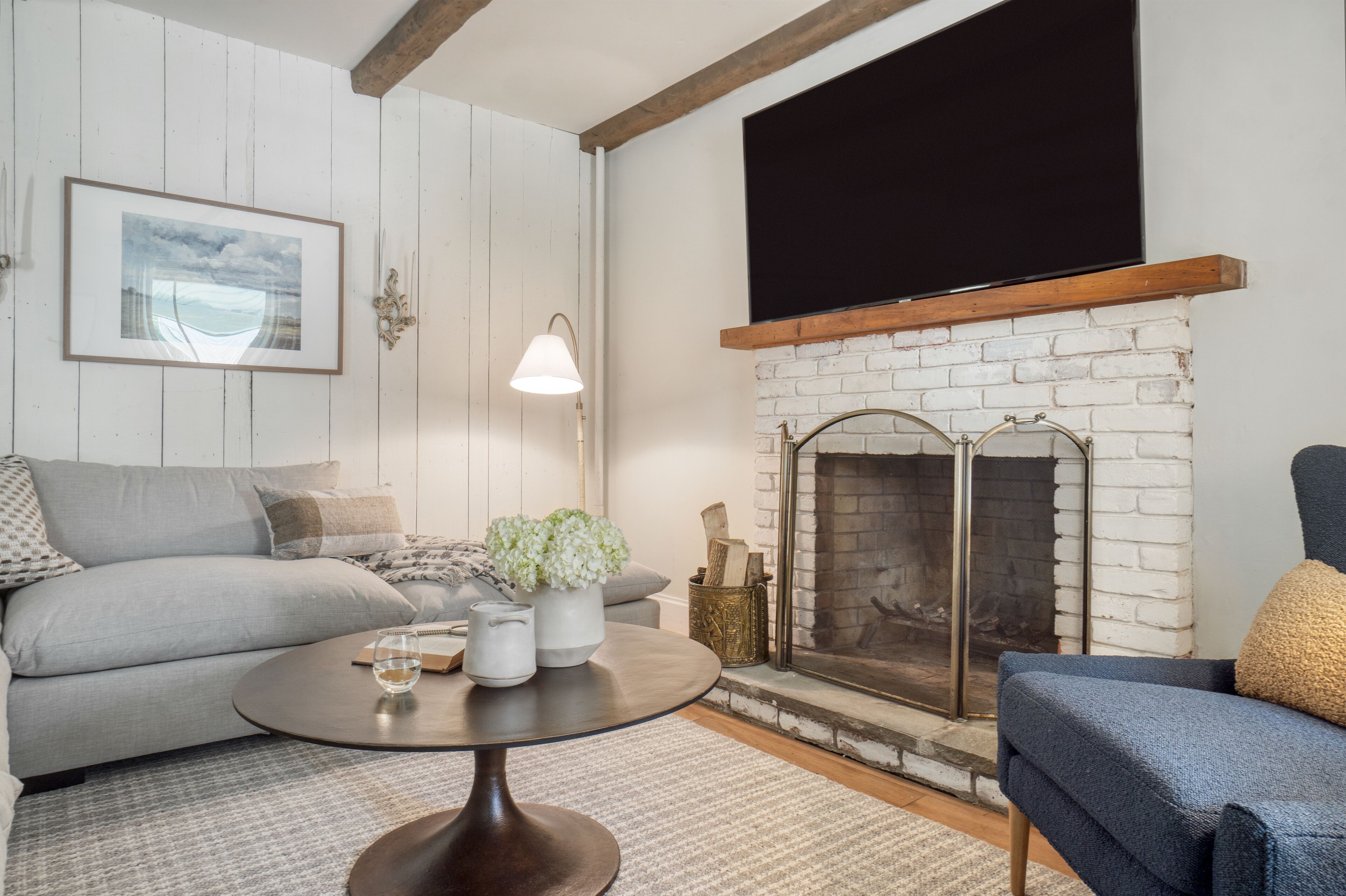 A living room with a fireplace, a sofa, a coffee table, and a television.