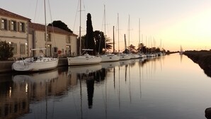 Ein Yachthafen mit mehreren Segelbooten, die an einem ruhigen Wasserweg vor Anker liegen.