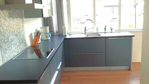 Una cocina moderna con una isla grande, horno empotrado y ventana que proporciona luz natural.
