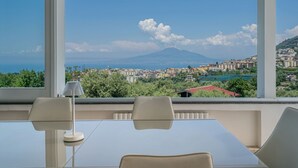 A room with a large window, a table, two chairs, and a lamp. - La Quiete, Exclusive Villa with private pool and Jacuzzi (Vico Equense)
