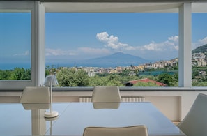 A room with a large window, a table, two chairs, and a lamp. - La Quiete, Exclusive Villa with private pool and Jacuzzi (Vico Equense)