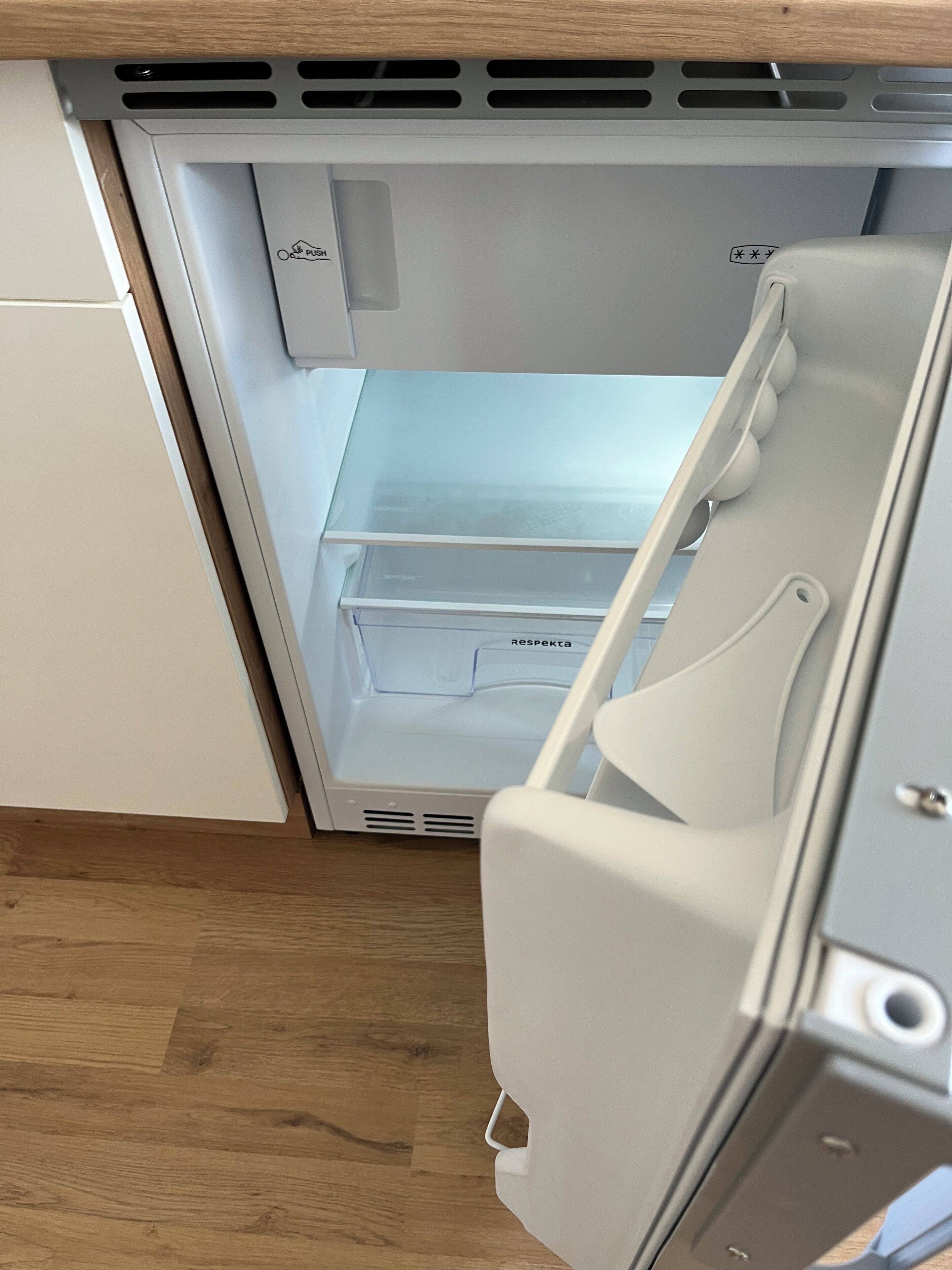 Et køleskab med frostboks, håndtag og kontrolpanel.