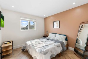 A bedroom with a bed, a window, a bedside table, and a mirror. - 5ST Tranquil Escape in Vibrant Scottsdale (Scottsdale)