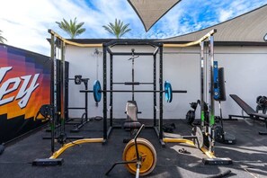 A gym with a squat rack, bench press, and various weightlifting equipment. - 5ST Tranquil Escape in Vibrant Scottsdale (Scottsdale)