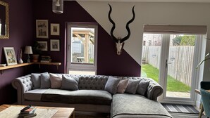 Una sala de estar con un sofá modular, una mesa de centro y una calavera de venado montada en la pared.