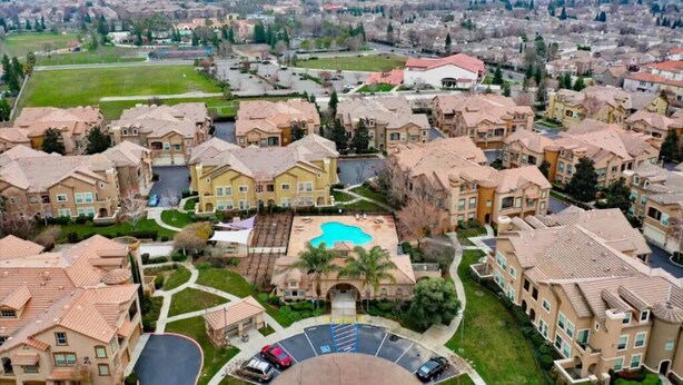 Un quartier résidentiel comprenant des immeubles d’appartements, une piscine et un parking.