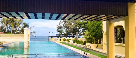 A swimming pool with a covered area and a view of the ocean.