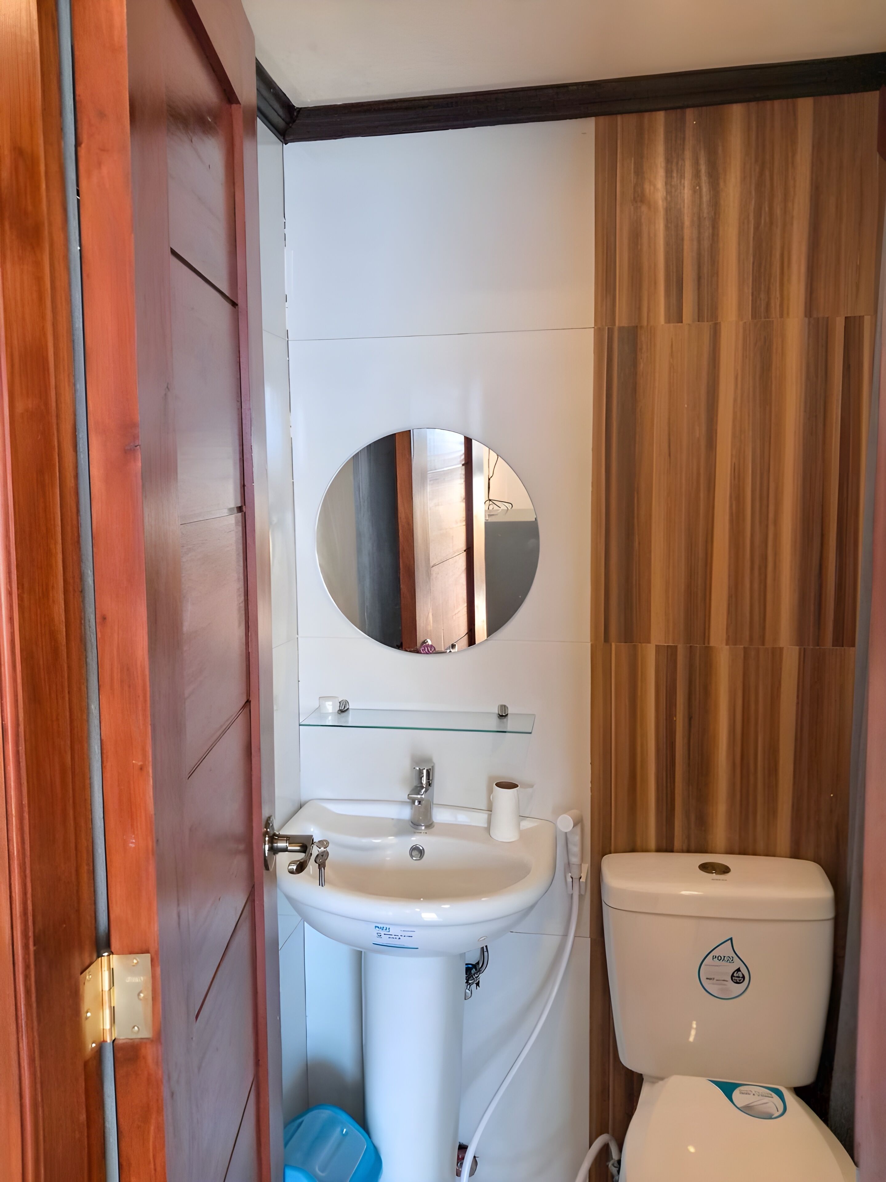 A bathroom with a white sink, a mirror, and a toilet.