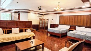 A spacious living area with a high ceiling, wooden furniture, and a chandelier. - Kasa Cailloux (Pasuquin)