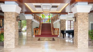 A grand foyer with a marble floor, a grand staircase, and a piano. - Kasa Cailloux (Pasuquin)