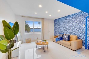 A modern living room with a sofa, coffee table, and large plant. - Modern Beachside: Restaurants, Pool (Hollywood)