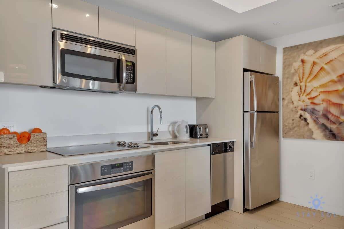 A modern kitchen with stainless steel appliances, a dishwasher, and a sink.