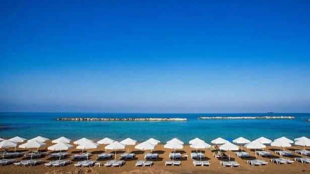 A beach with rows of white umbrellas and sun loungers facing the sea. - Sunset view every night from your own balcony!

 (Paphos)