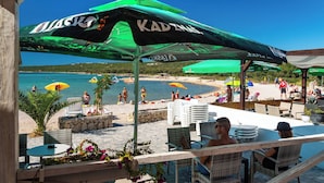 A beachside café with outdoor seating and umbrellas. - Studio Apartments Near Center 4 (Novalja)