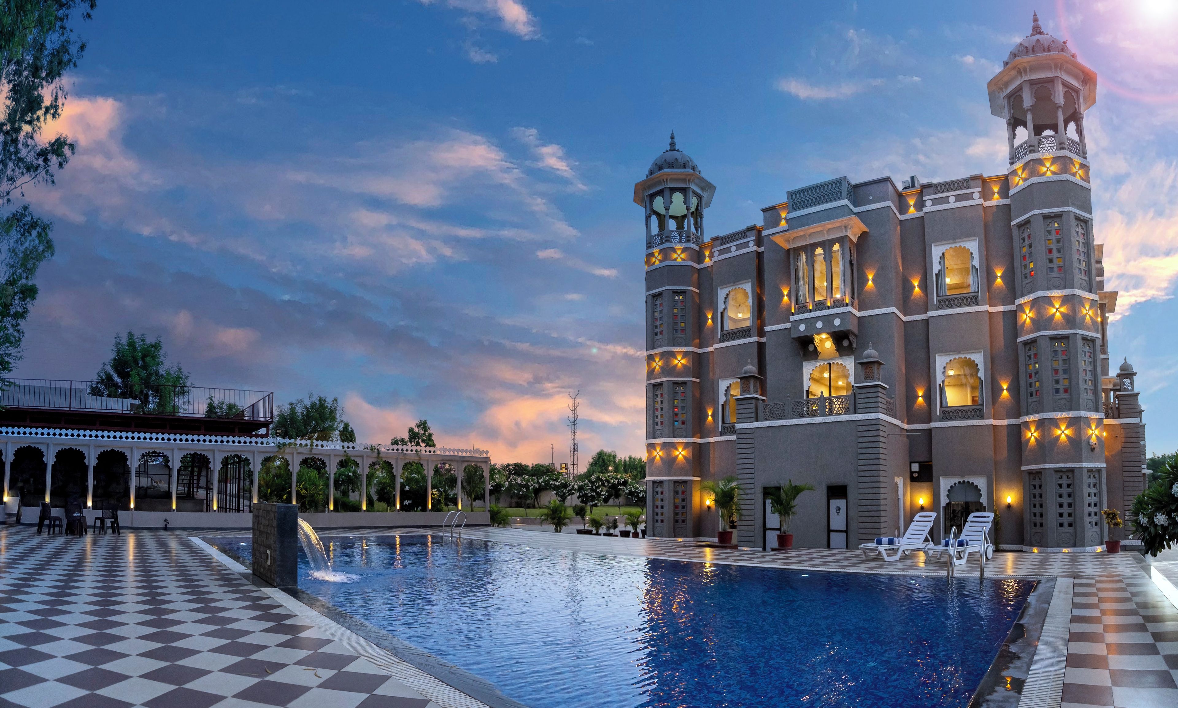 A large building with multiple towers and a swimming pool.