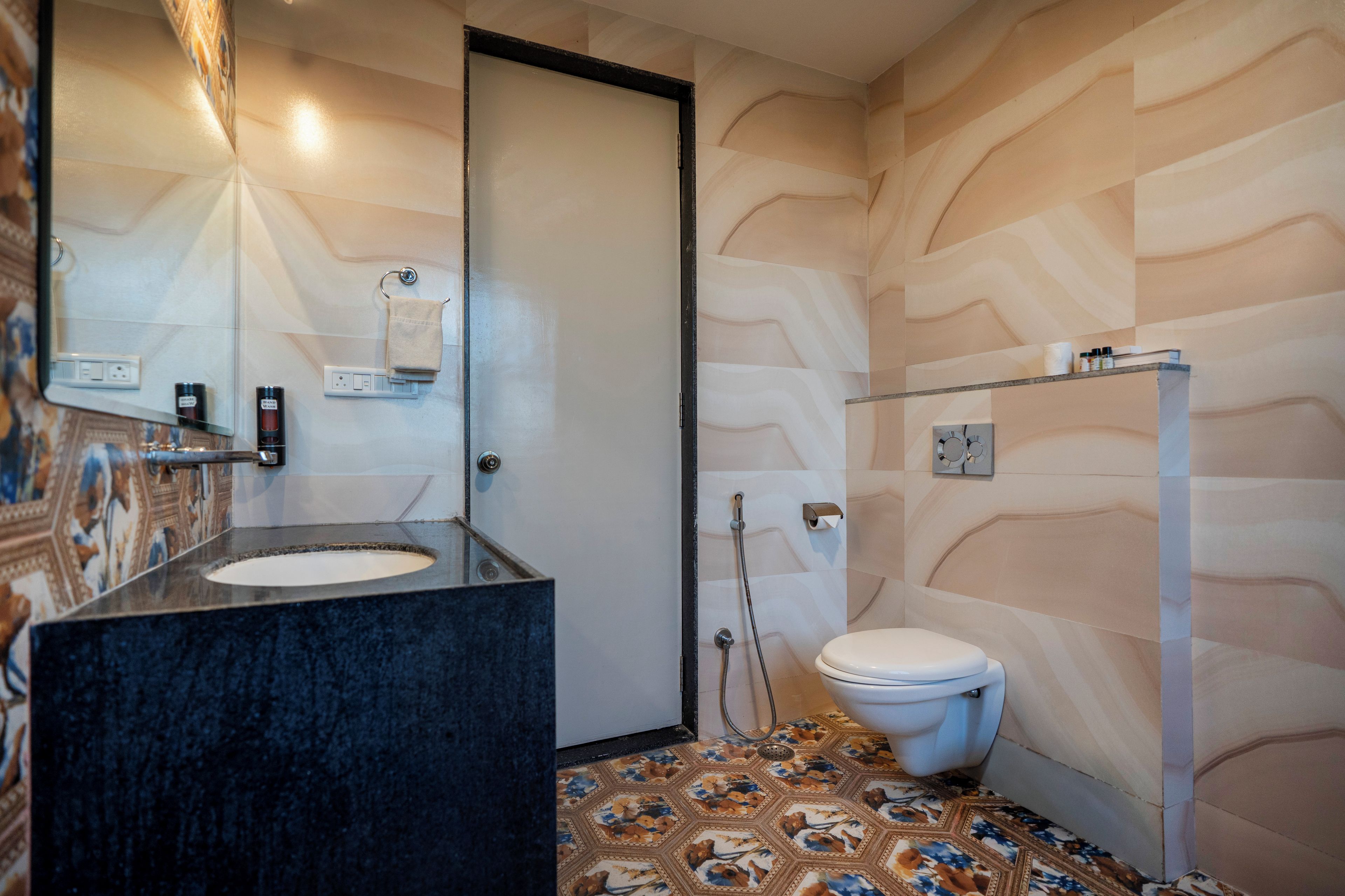 A bathroom with a black sink, a toilet, and a shower area.