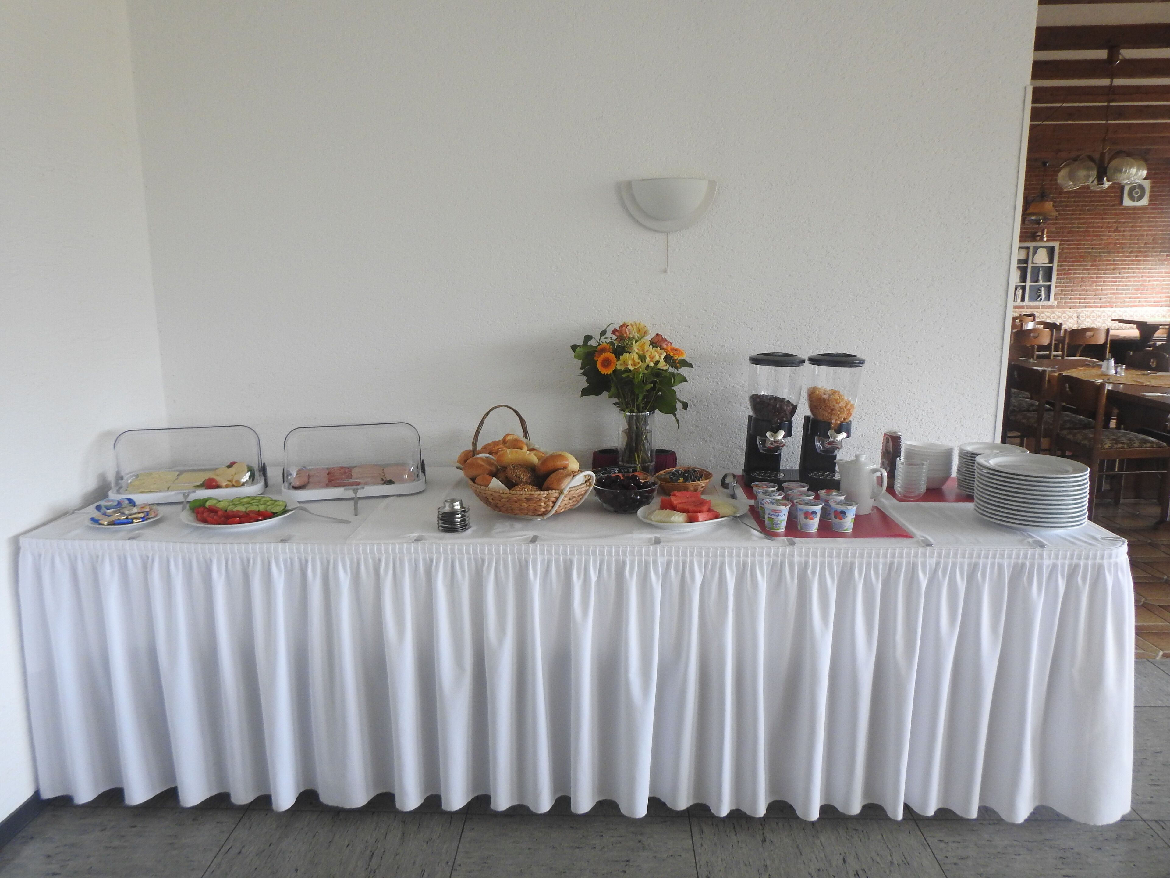 Une table de buffet proposant divers plats et un coin café.