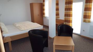 Une chambre avec un lit, un bureau, une chaise et une armoire.