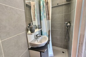 Een douche, een haardroger, handdoeken, toiletpapier