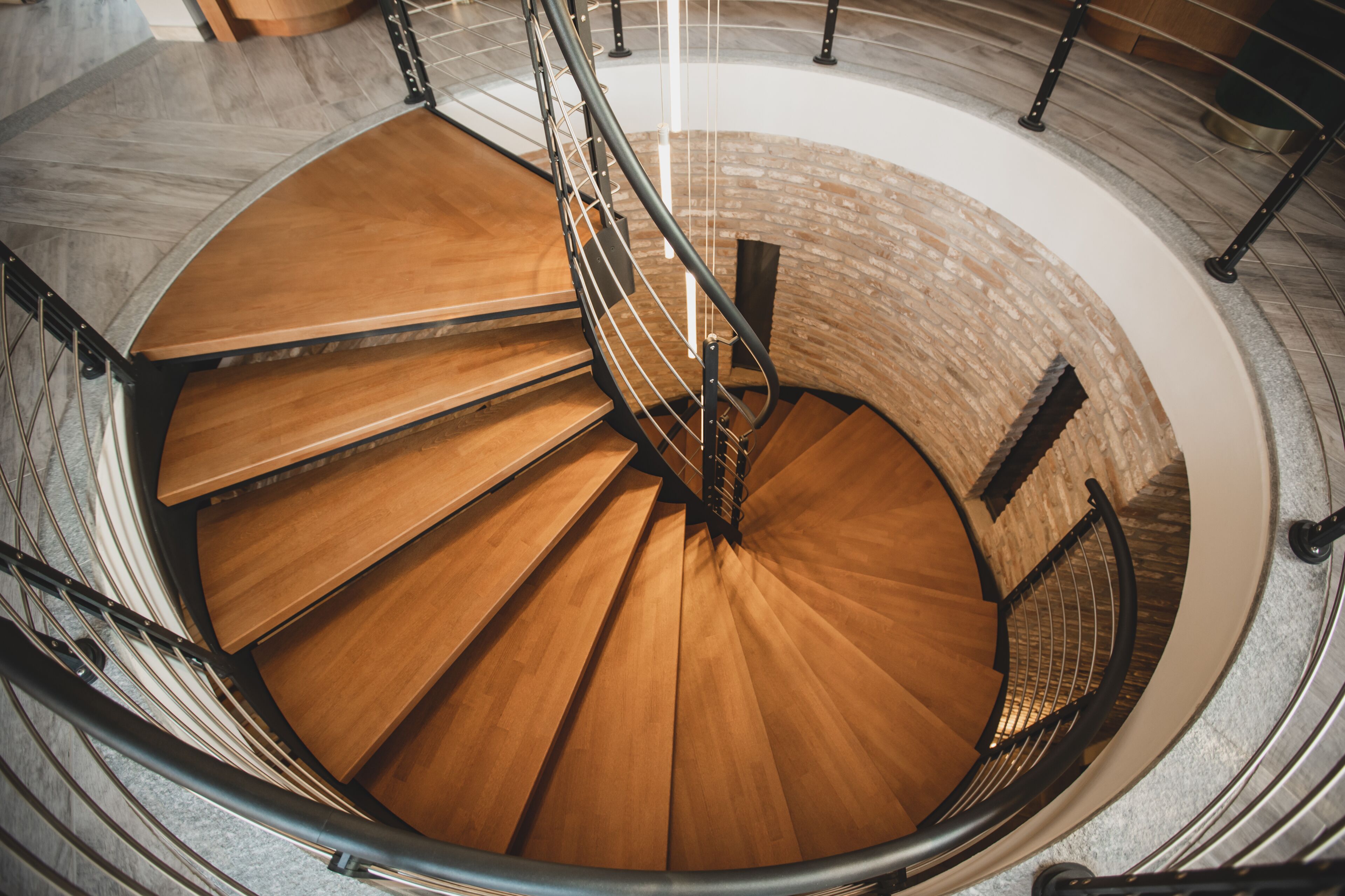 A spiral staircase with wooden steps and metal railings.