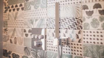 A wall with various patterned tiles, including tropical leaf designs and geometric shapes.