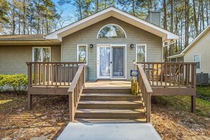 A two-story house with a front porch, a front door, and a small deck on each side. - Pet Friendly Home in Popular Ocean Pines (Ocean Pines)
