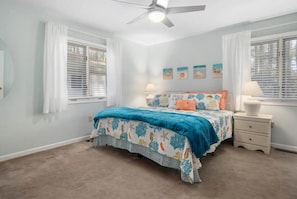 A bedroom with a bed, two bedside tables, a ceiling fan, and a window with blinds. - Pet Friendly Home in Popular Ocean Pines (Ocean Pines)