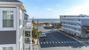 Un hôtel situé sur la côte, doté d’un parking, offrant une vue sur la plage et comprenant un immeuble à plusieurs étages avec des balcons.