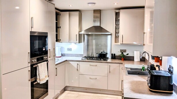 A modern kitchen with stainless steel appliances, a gas stove, and a range hood. - Places to stay in Darlington with Free Parking (Darlington)