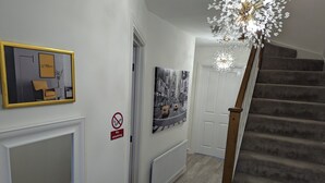 A hallway with a 'No smoking' sign, a framed picture, a radiator, and a staircase. - Places to stay in Darlington with Free Parking (Darlington)