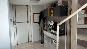 A compact living space with a closed door, a staircase, and a shelf with audio equipment. - Refuge of Lambrate - Milano Centrale (Milano)