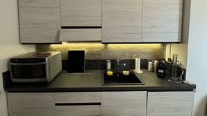 A modern kitchen with a built-in microwave, a toaster, and a sink with various utensils. - Refuge of Lambrate - Milano Centrale (Milano)