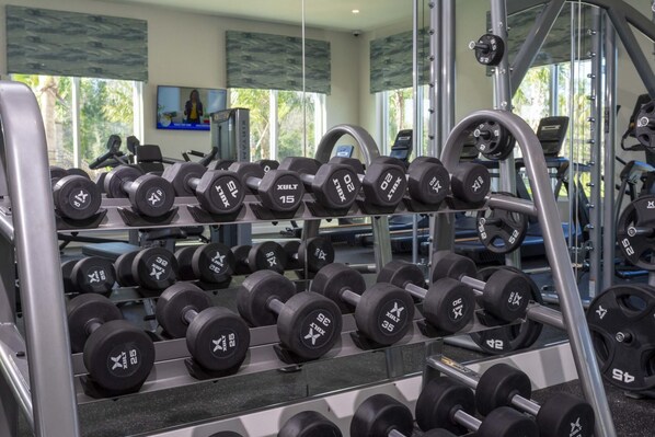 A gym with multiple rows of adjustable dumbbells. - Gorgeous 4 Bd w Pool Storey Lake Resort 2485 (Kissimmee)
