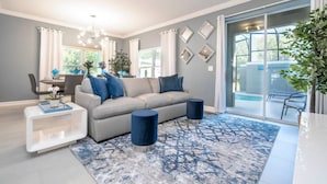 A modern living room with a sofa, coffee table, and two accent chairs. - Wonderful 5 Bd w Pool Storey Lake Resort 2545 (Kissimmee)