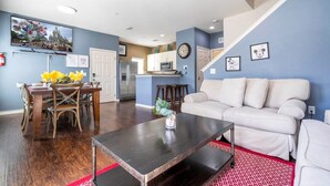 A living room with a sofa, coffee table, and dining area with chairs and a table. - Marvelous 4 Bd Close To Disney West Lucaya 8959 (Kissimmee)