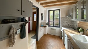Une cuisine avec des poutres en bois, une fenêtre et un évier.