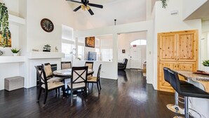 A spacious dining area with a round table and chairs, a ceiling fan, and wooden cabinets. - Chic Vegas Retreat: Near Top Attractions (Las Vegas)
