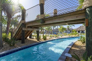 A pool area with a wooden deck, palm trees, and a rope bridge. - Stunning 5 Bd w Pool Storey Lake Resort 2653 (Kissimmee)