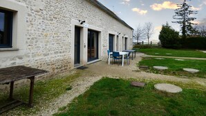 A stone building with a gravel patio, outdoor seating, and a view of the sky. - Charming Contemporary Farm Gîtes in Scenic Beauce Village, Private Garden & Parking (Moutiers)