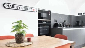 A modern kitchen with a Bosch oven, a coffee machine, and a sign reading "HARLEY STREET W1".